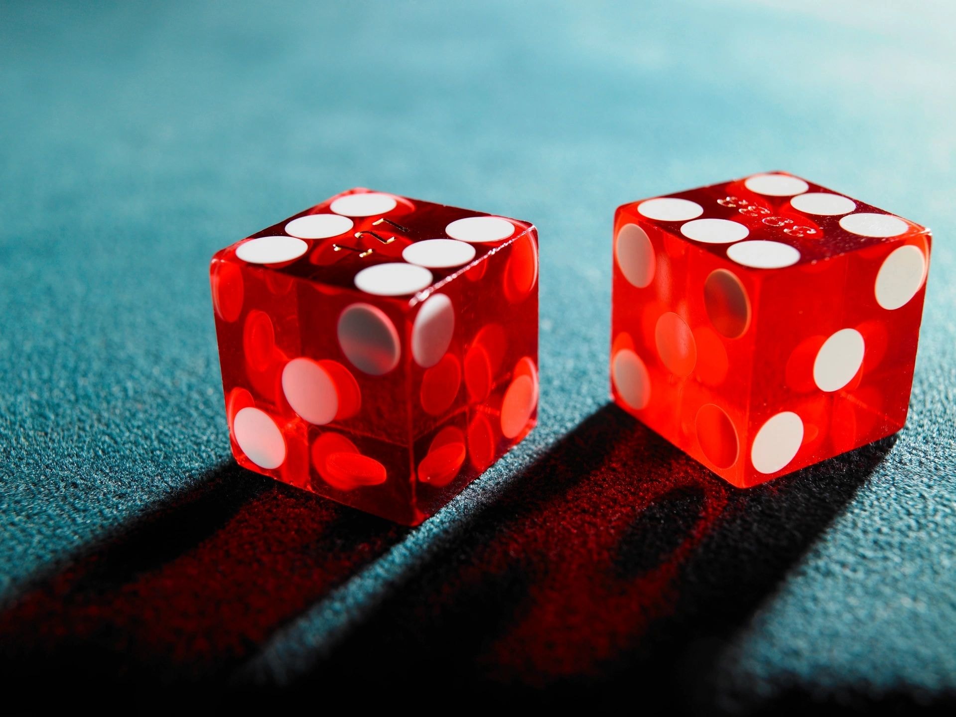 Red translucent dice on teal background